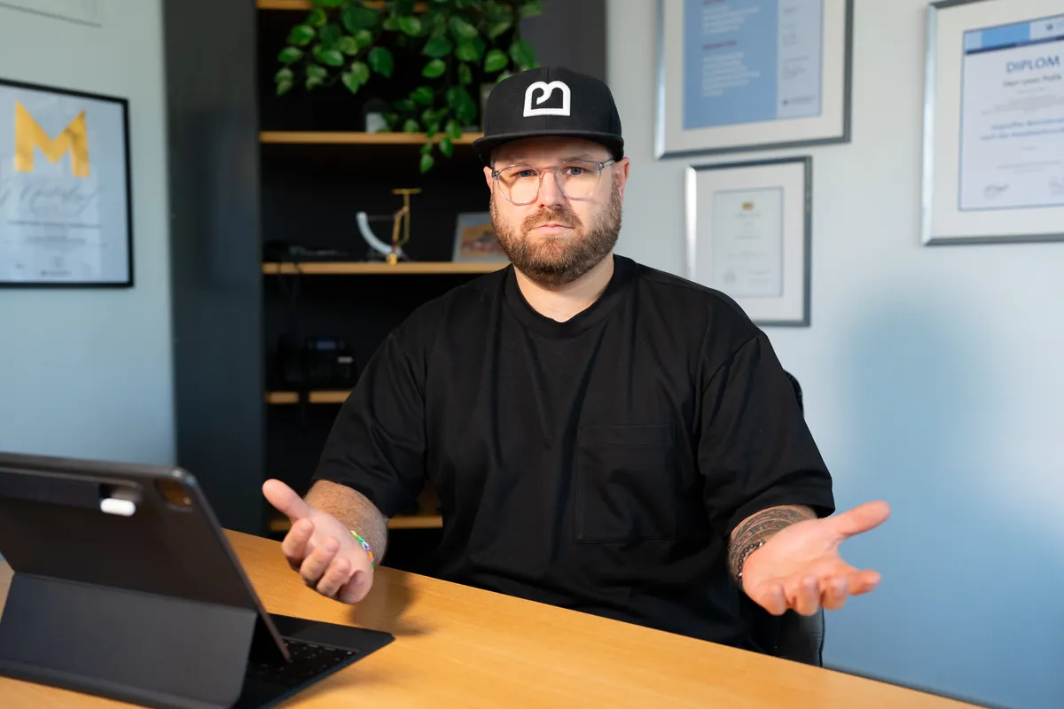 Felix Zimmermann berät am Schreibtisch, vor ihm das Tablet